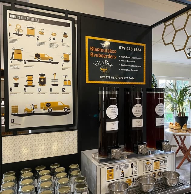 The honey-on-tap station in the VitaBee shop, with three honey pods and a wall of empty jars